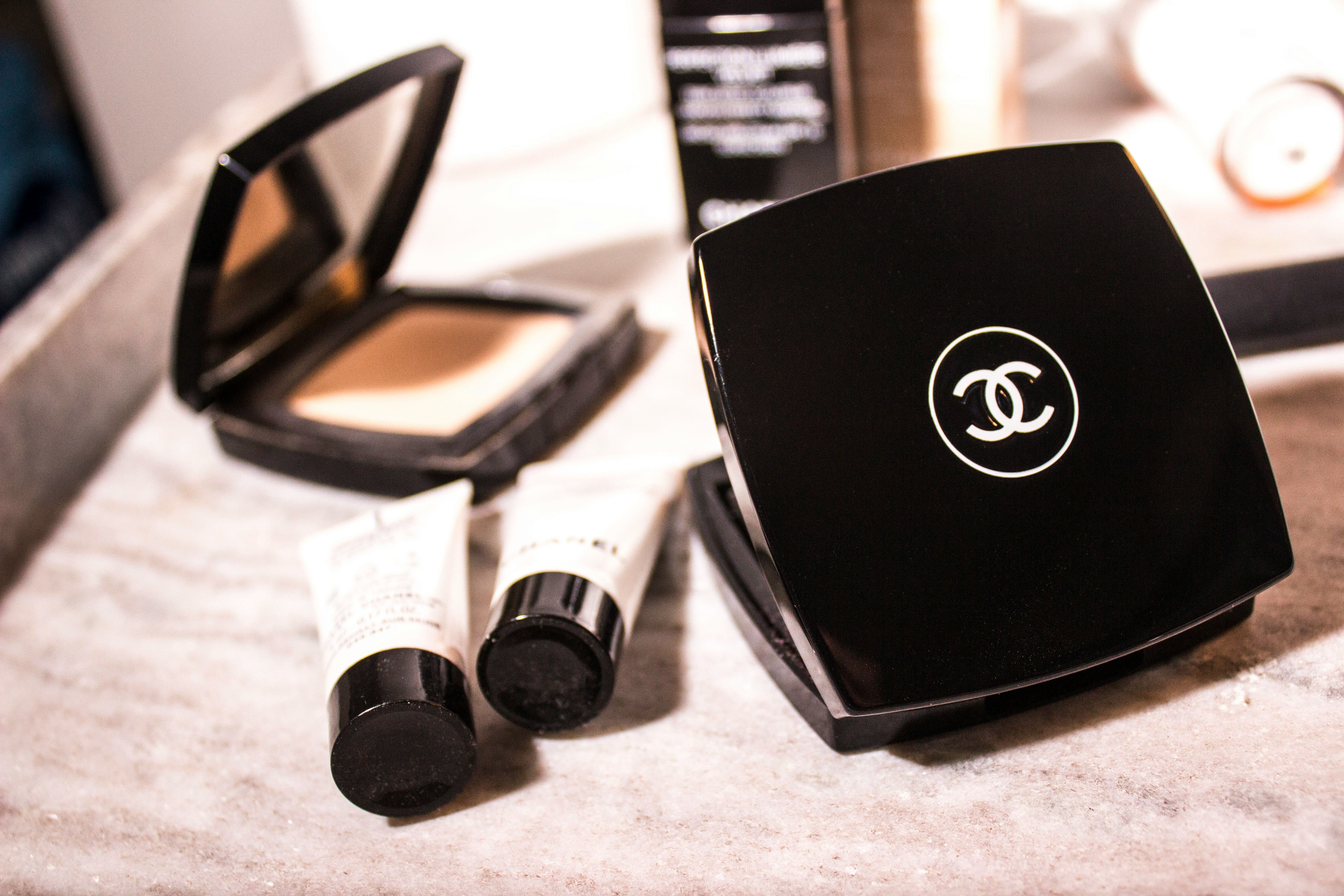 An image of two open powder compacts and two small concealer tubes.